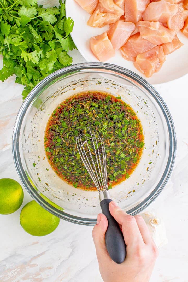 soy sauce, honey, oil, lime juice, Sriracha, garlic and cilantro in a clear glass bowl.