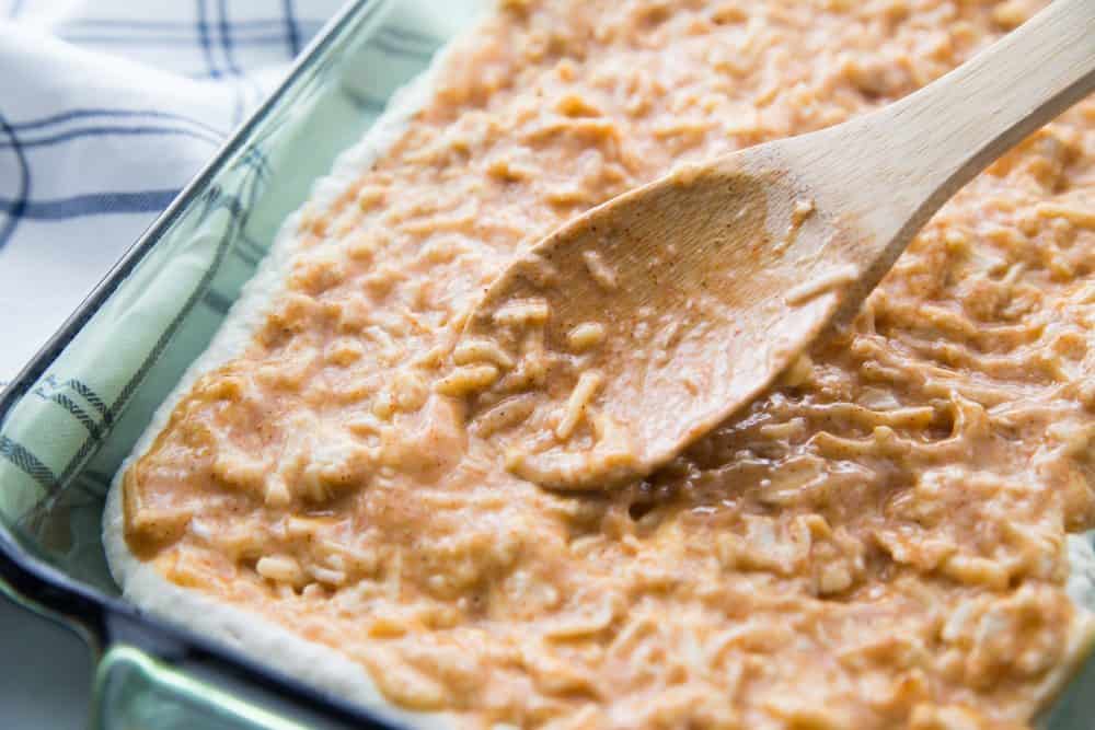 REFRIED BEANS AND SHREDDED CHEESE SPREAD OVER BISQUICK LAYER