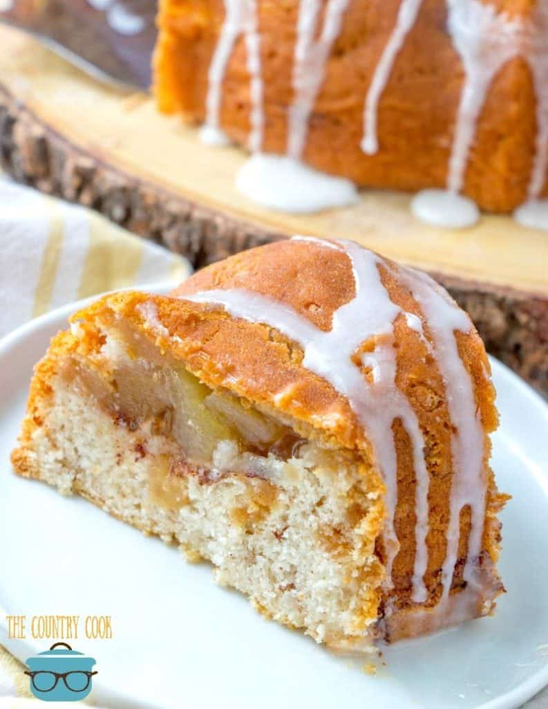 apple cider bundt cake with apple pie filling inside on a small white plate.