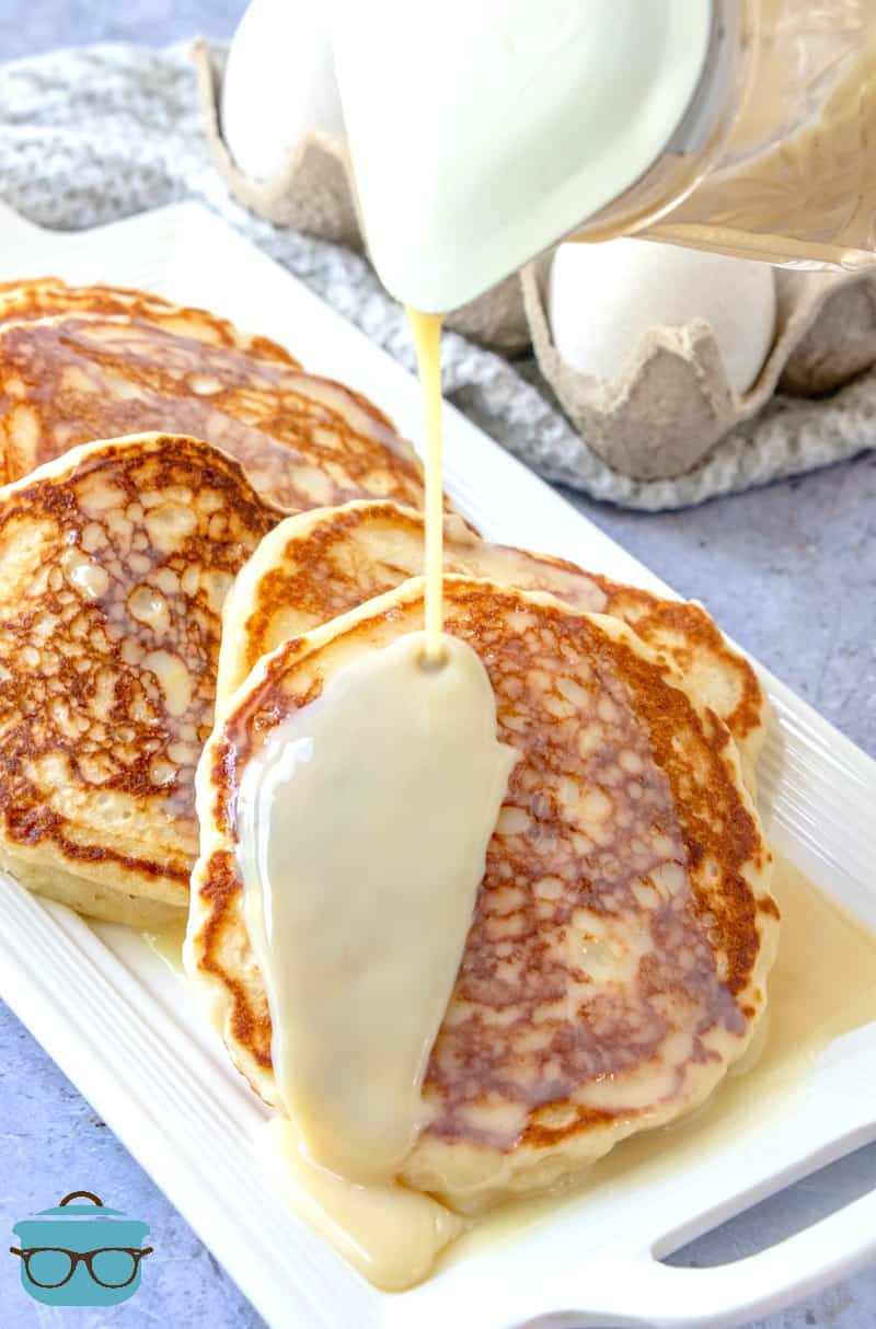 Griddle-fried Buttermilk Pancakes with Maple Butter Sauce poured on top.
