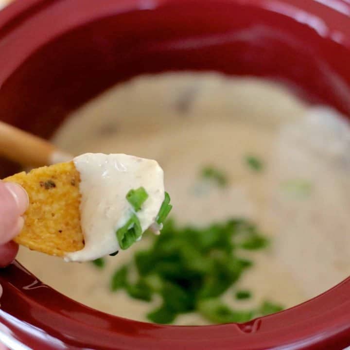 Dipping a Frito chip into warm french onion dip