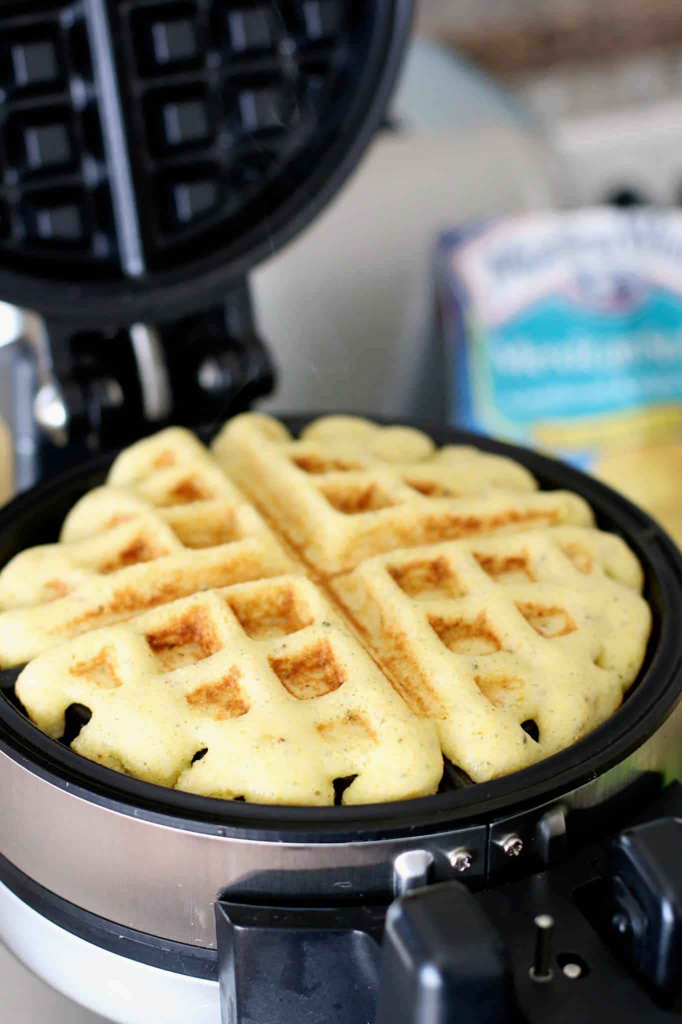 fully cooked cornbread waffle shown on the waffle iron. 