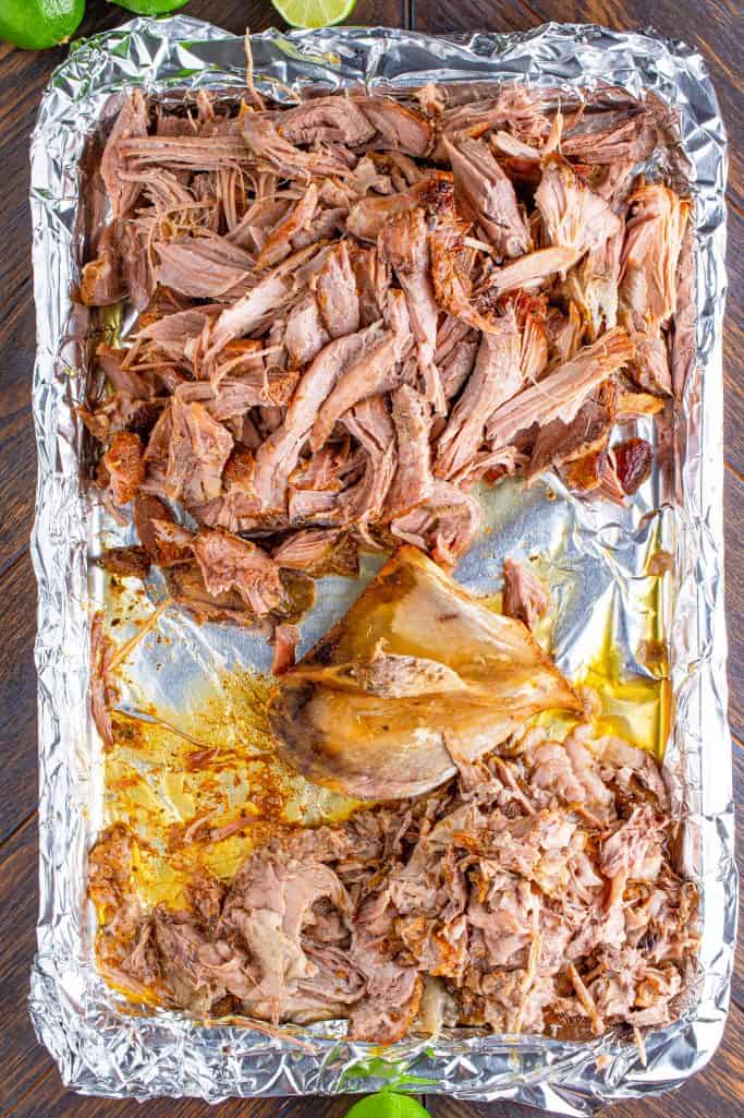 shredded pork shown on a tray lined with aluminum foil