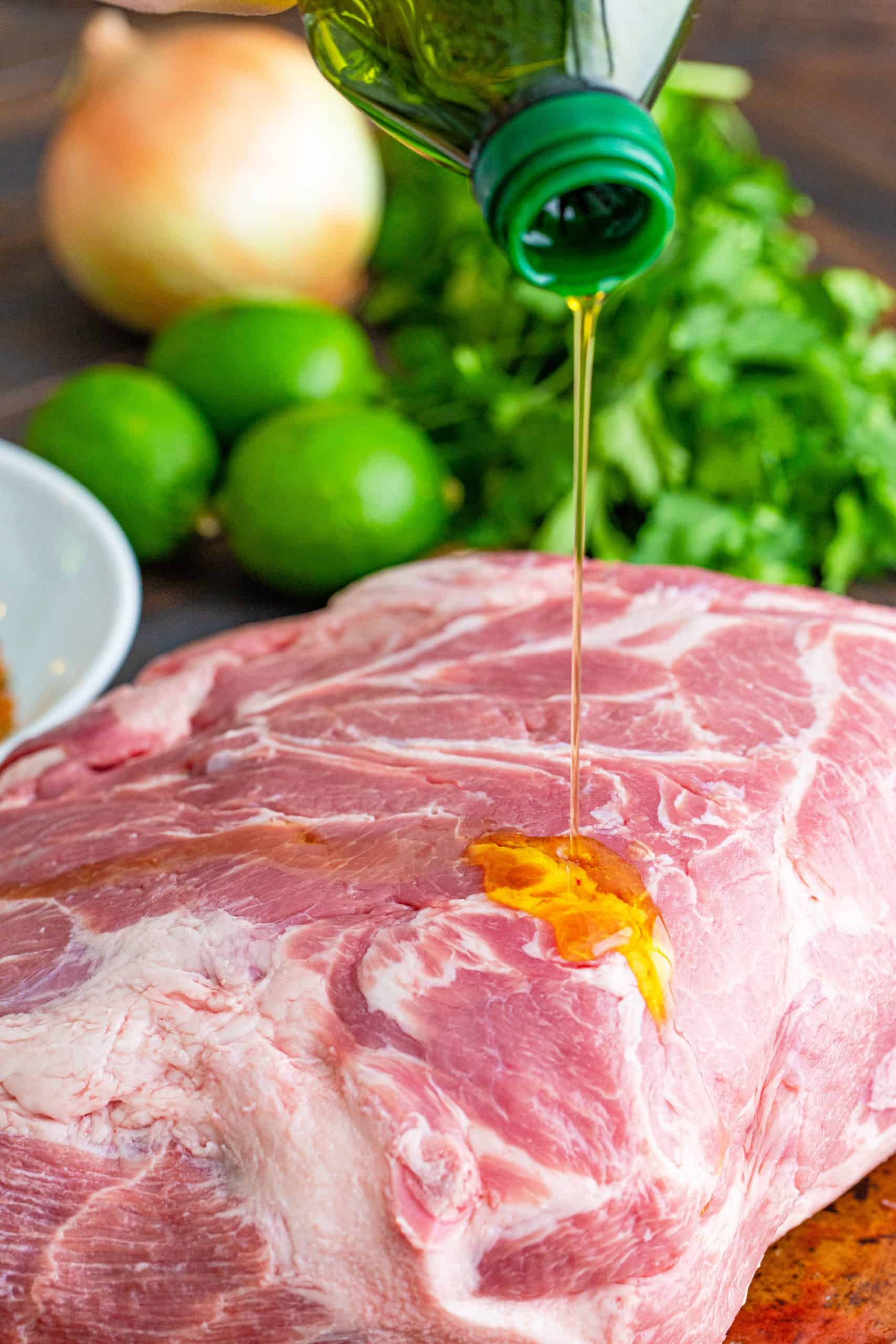 pouring olive oil on a pork roast.