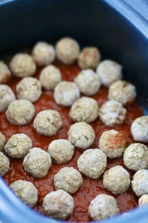 layer of spaghetti sauce and layer of frozen meatballs in an oval slow cooker