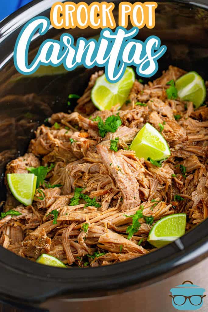 Slow Cooker pork carnitas recipe from The Country Cook, shredded pork shown in a slow cooker with pieces of lime