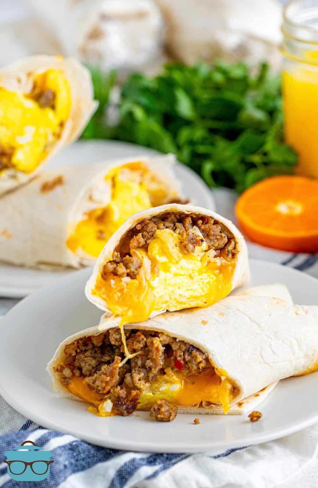 a breakfast burrito sliced in half and stacked on top of each other on a white plate.