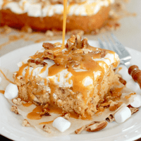Cake Mix Sweet Potato Cake with Marshmallow Frosting topped with chopped pecans and salted caramel sauce