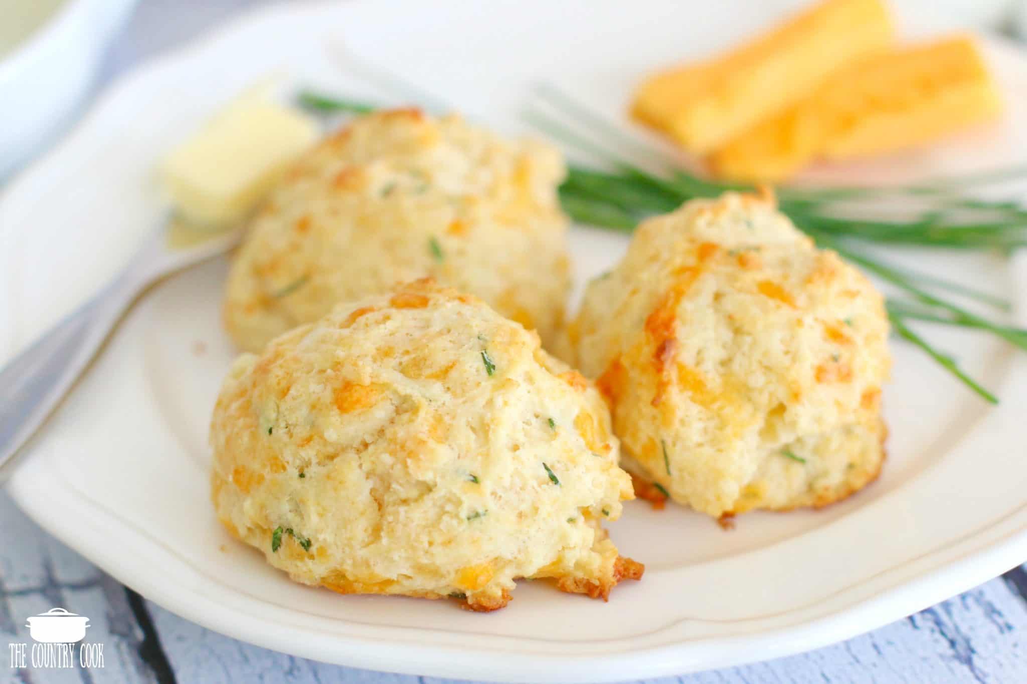 three Cheese Chive Drop Biscuits shown on a white plate. 