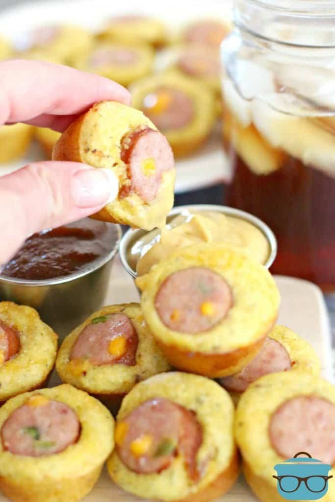 dipping cornbread muffin sausage bites into honey mustard