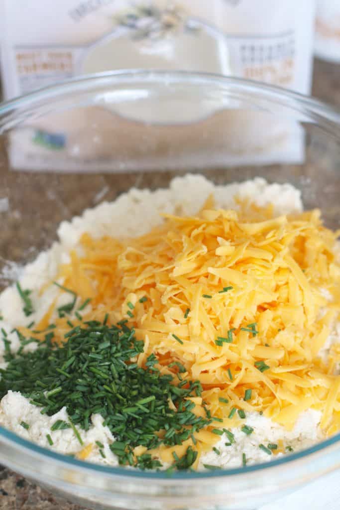 shredded cheddar, chopped chives and biscuit mix in a bowl