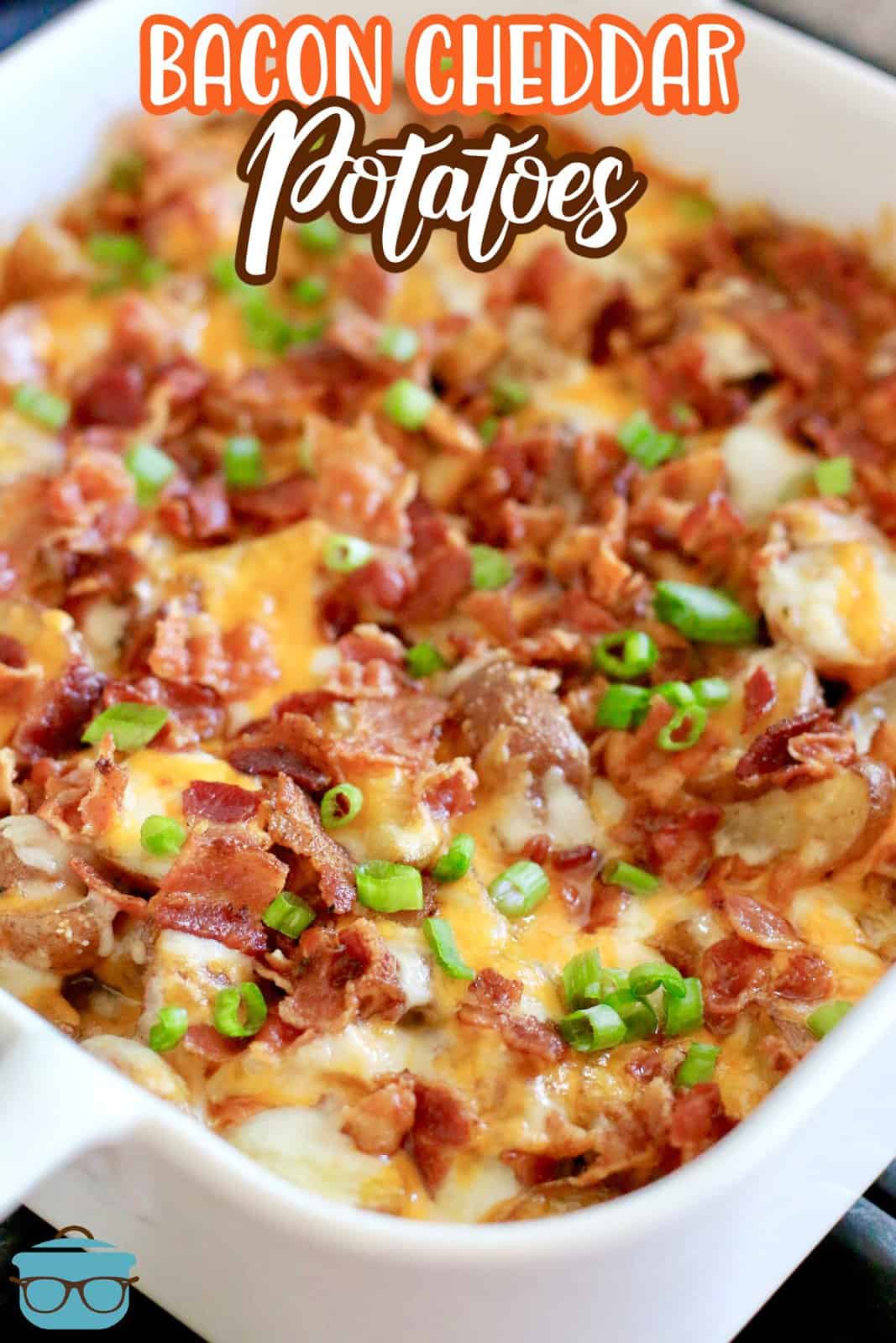 fully cooked baby potatoes in a white square baking dish topped with melted cheese and cooked bacon.