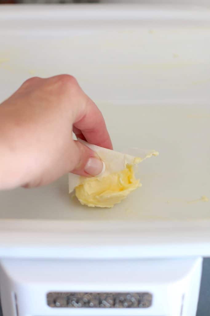 spreading butter in a crock pot.