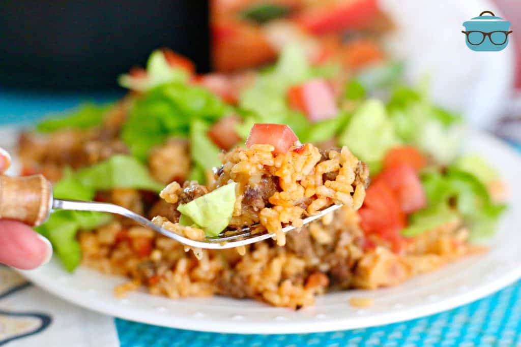 One Pan Taco Rice on a plate with a fork holding up a small serving.