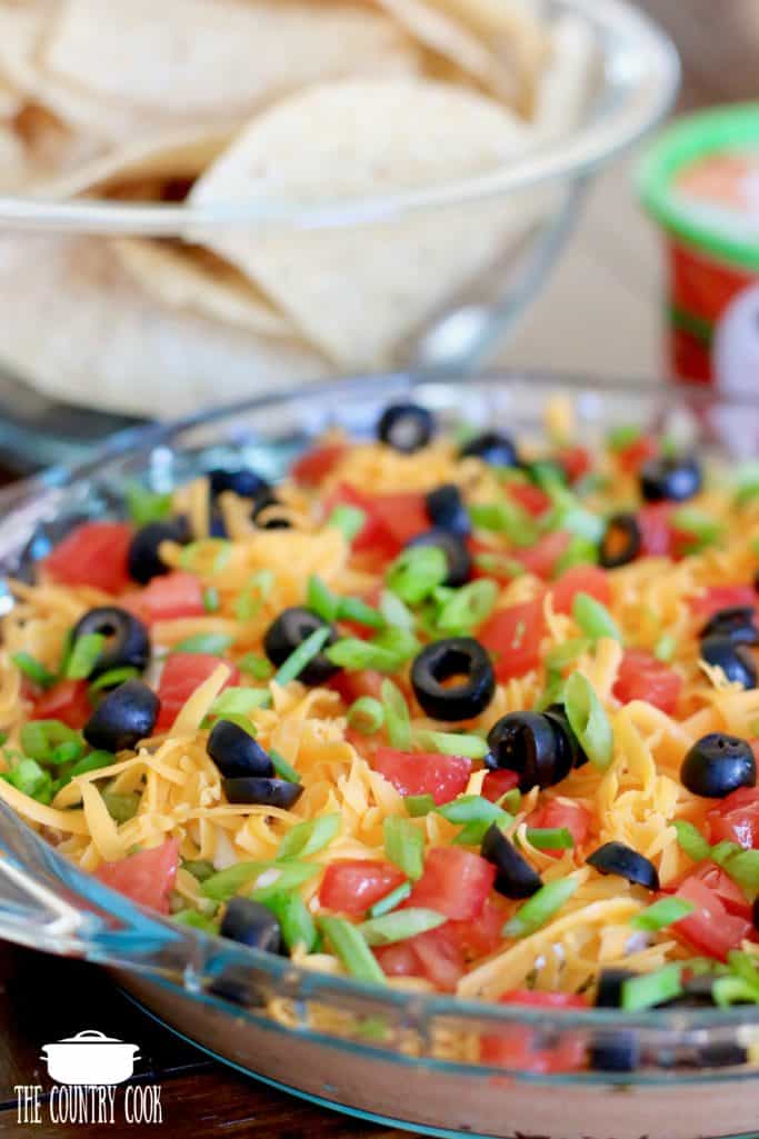 7 Layer Dip with beans, guacamole, ranch dip, cheese, tomatoes, green onions and olives