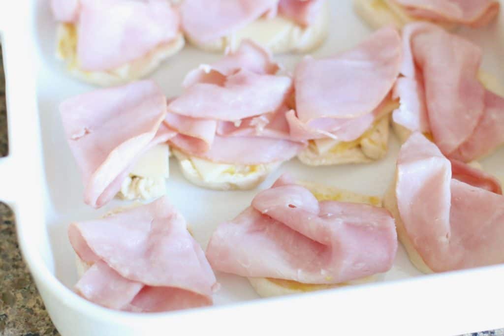 sliced ham on biscuits in baking dish