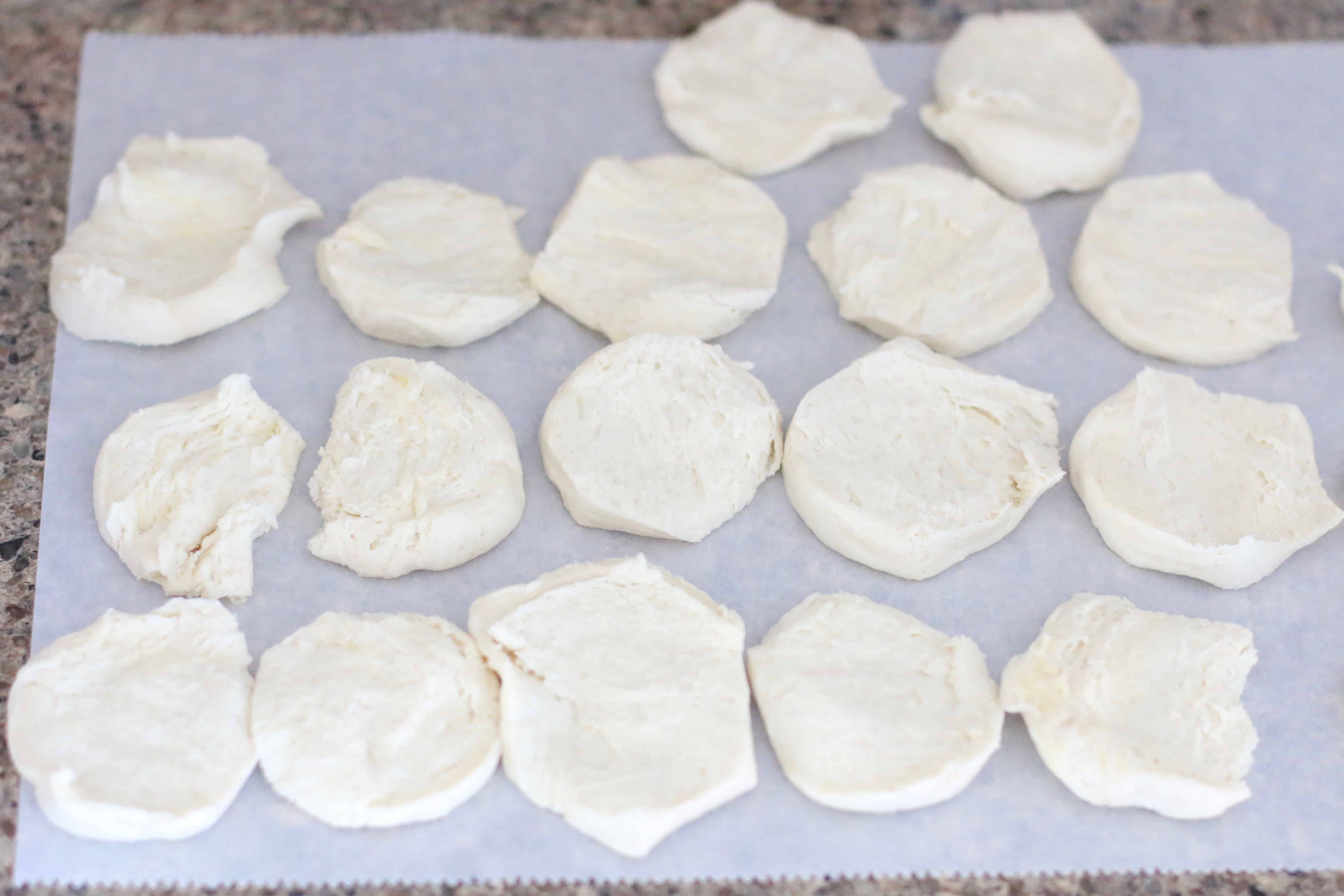 biscuit slices laid out on parchment paper.