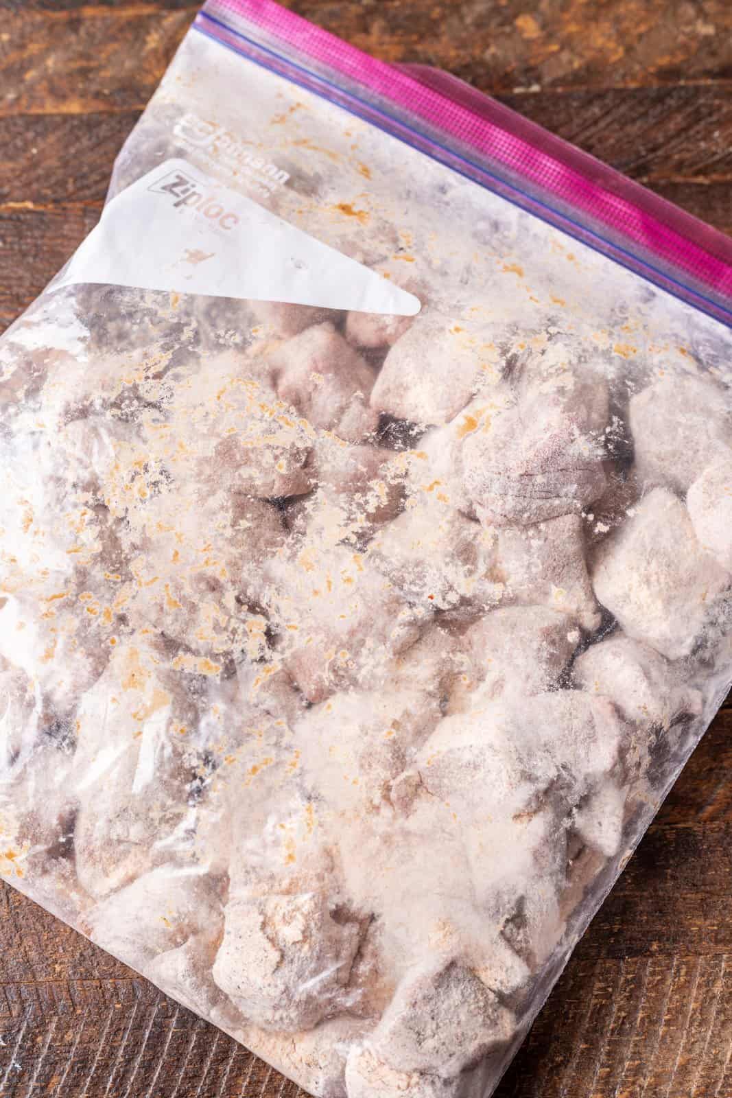 beef stew meat in a ziploc bag with flour.