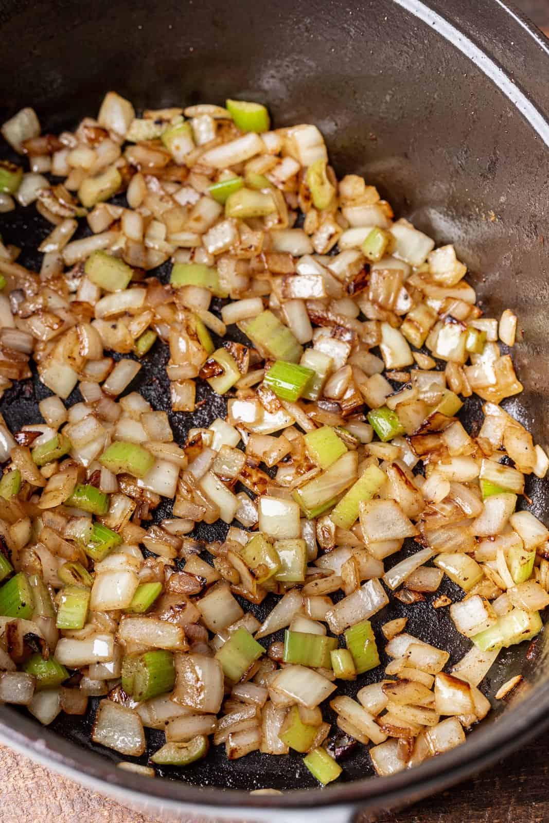 diced onions and celery added to a large pot with oil.