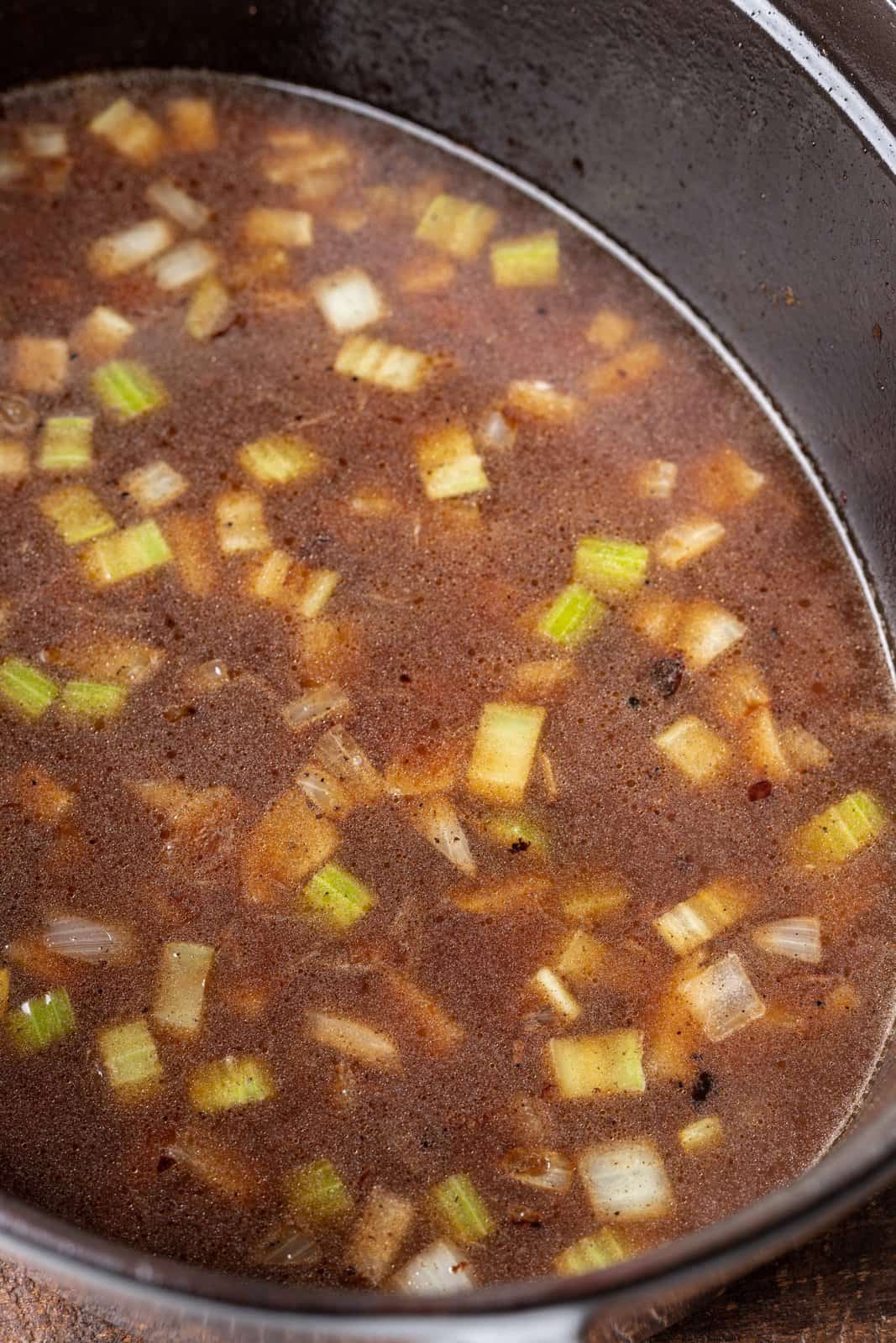 water, beef bouillon and beef stock added to pot with celery and onions. 