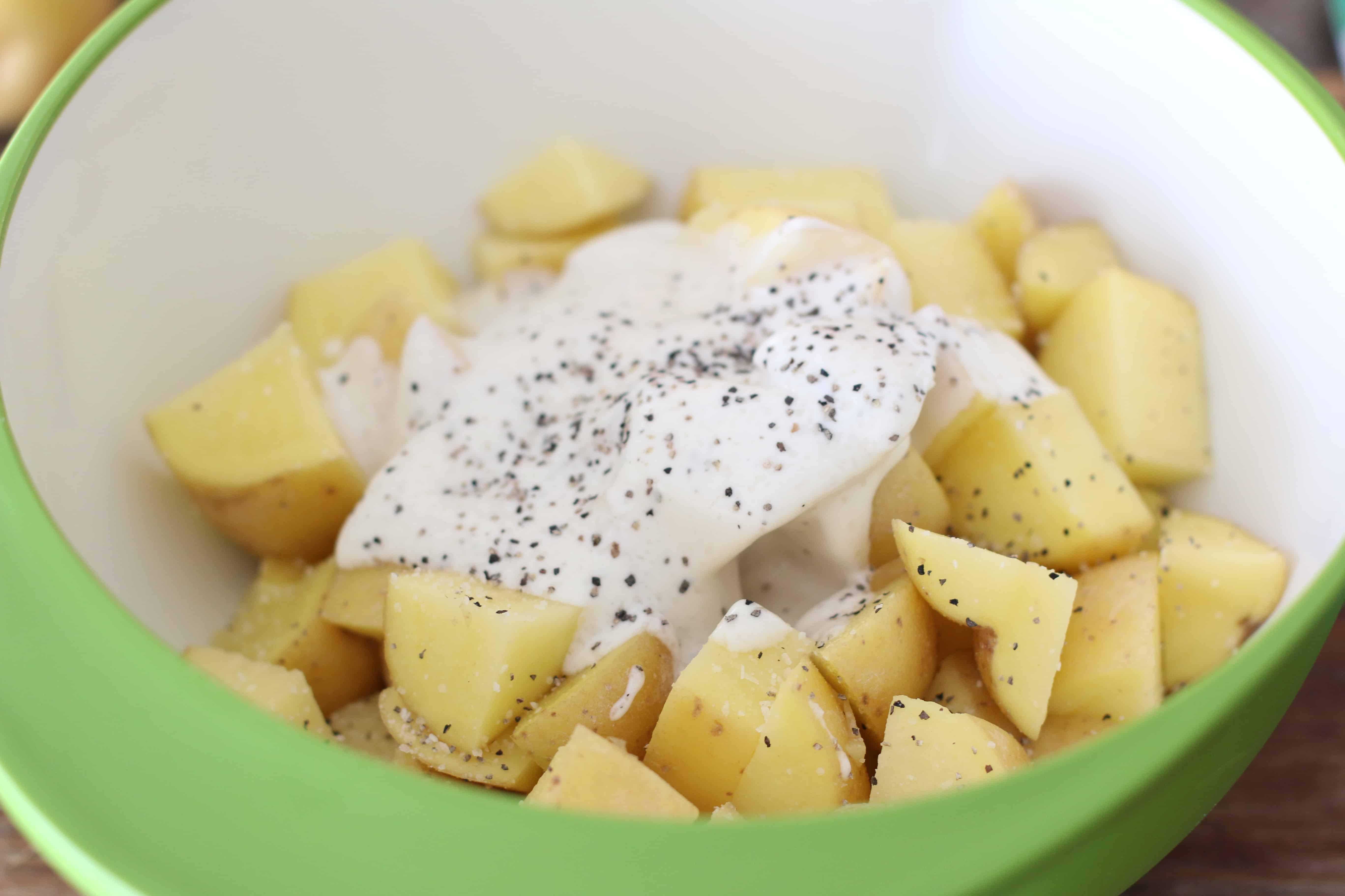 diced potatoes, ranch dressing, salt and pepper in a bowl.