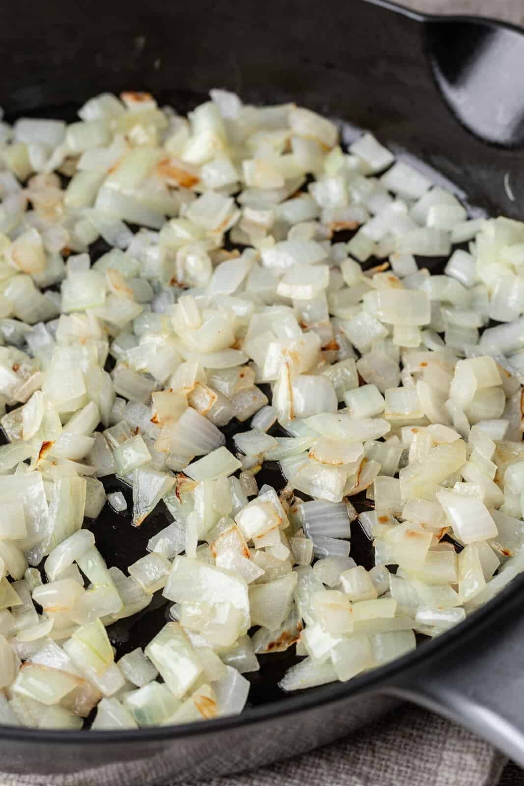 diced onions cooking with butter in a large skillet. 