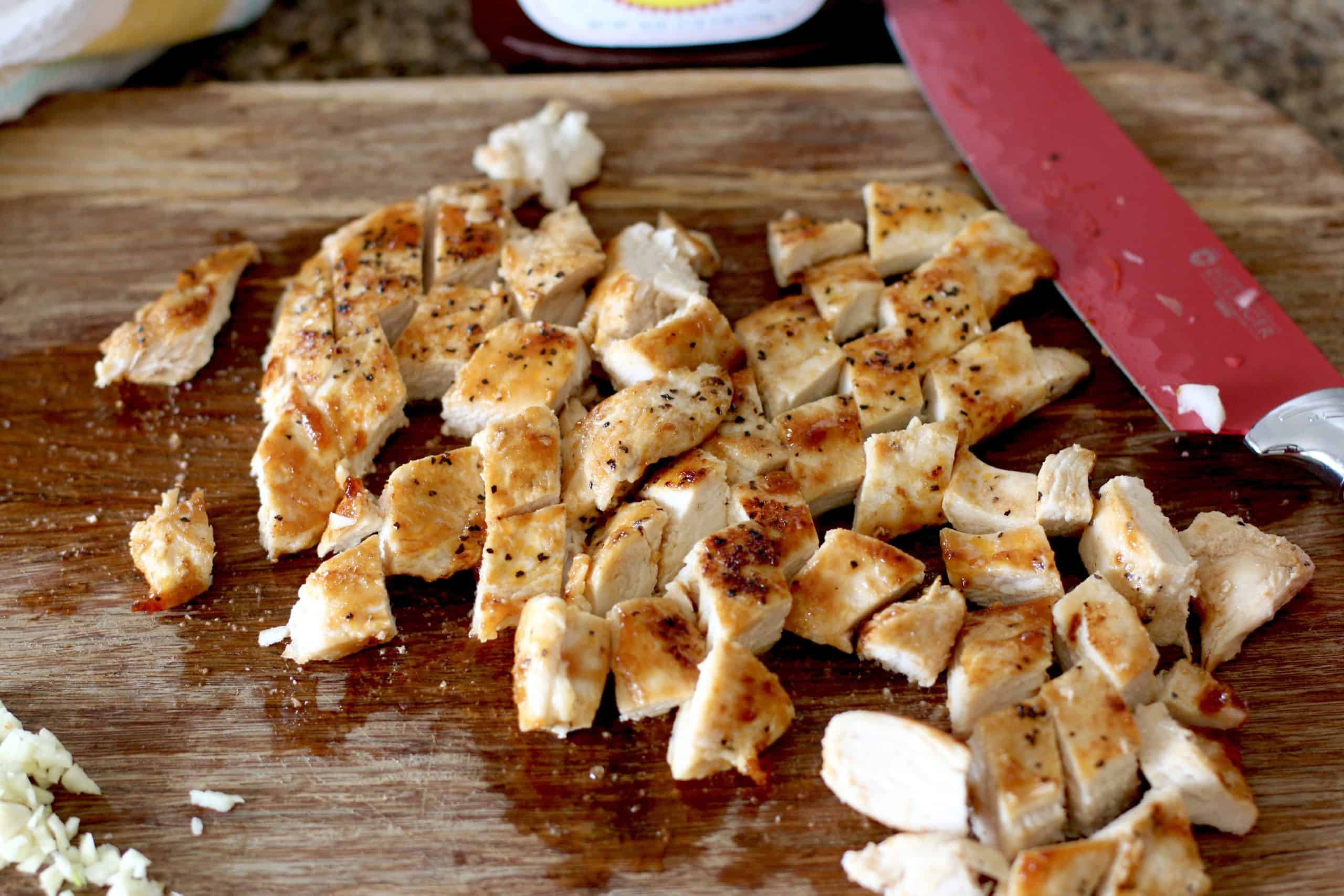 diced cooked chicken on a cutting board.