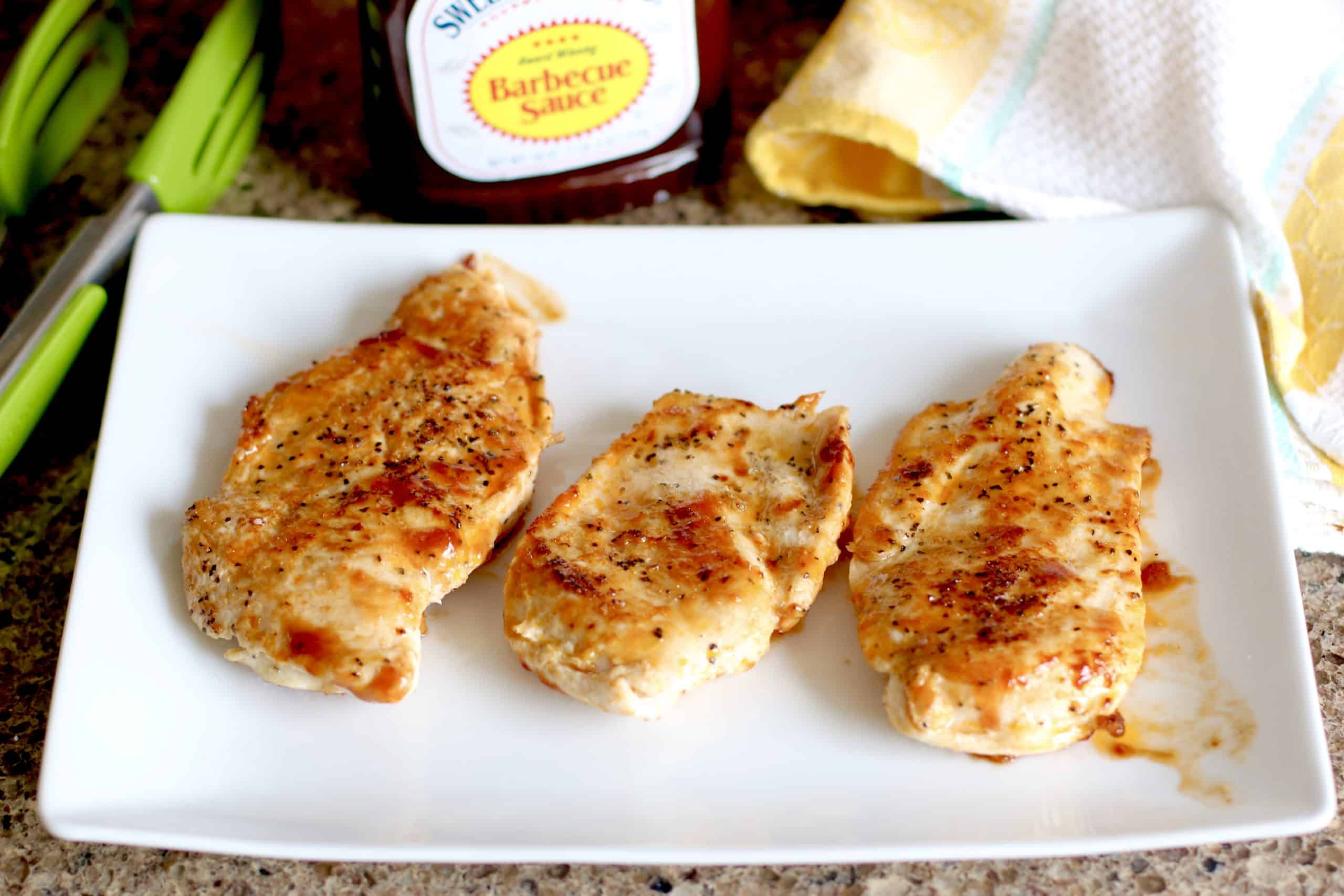 chicken breasts, fully cooked and set aside on a white platter.