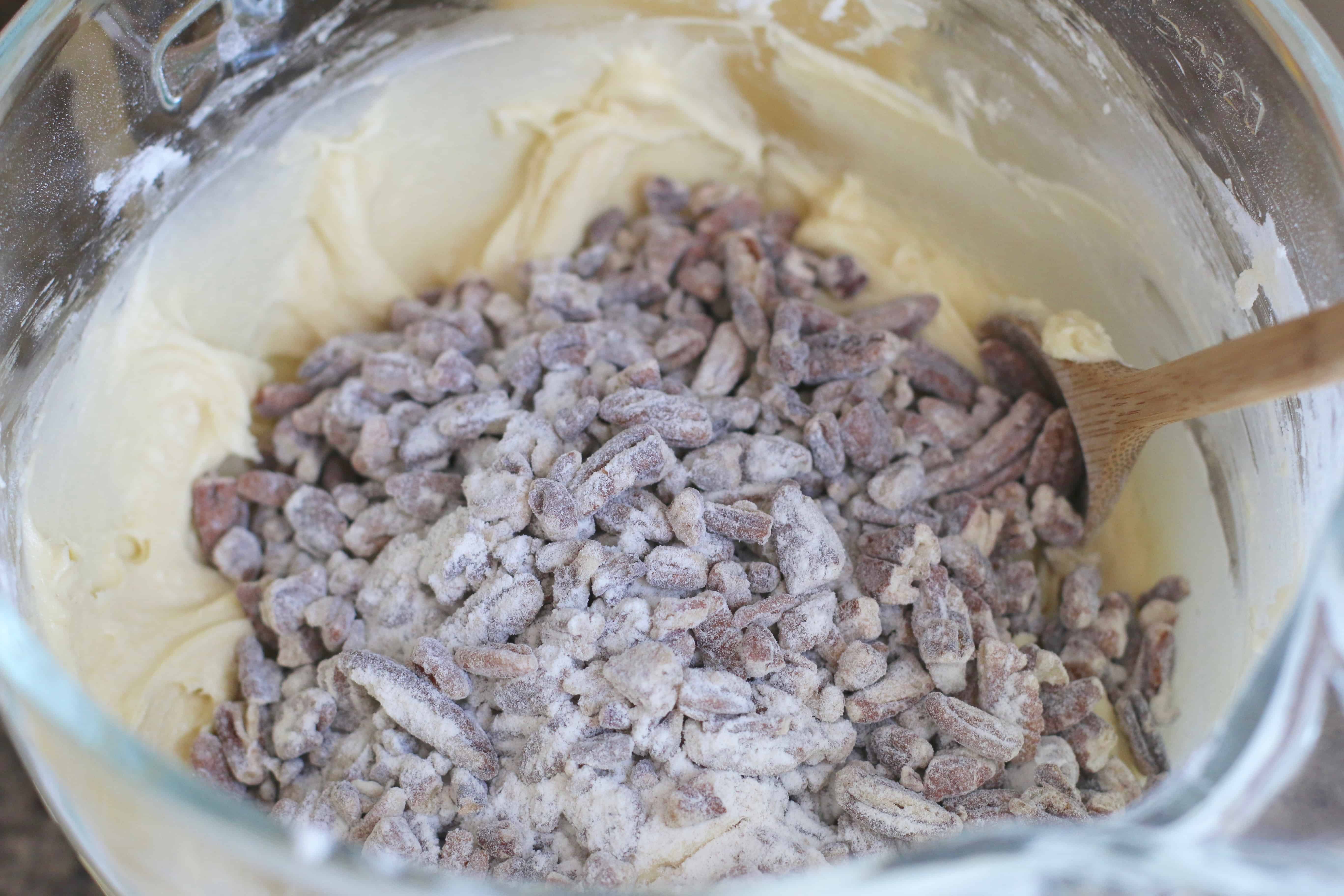 flour coated pecans added to pound cake batter in a large bowl.
