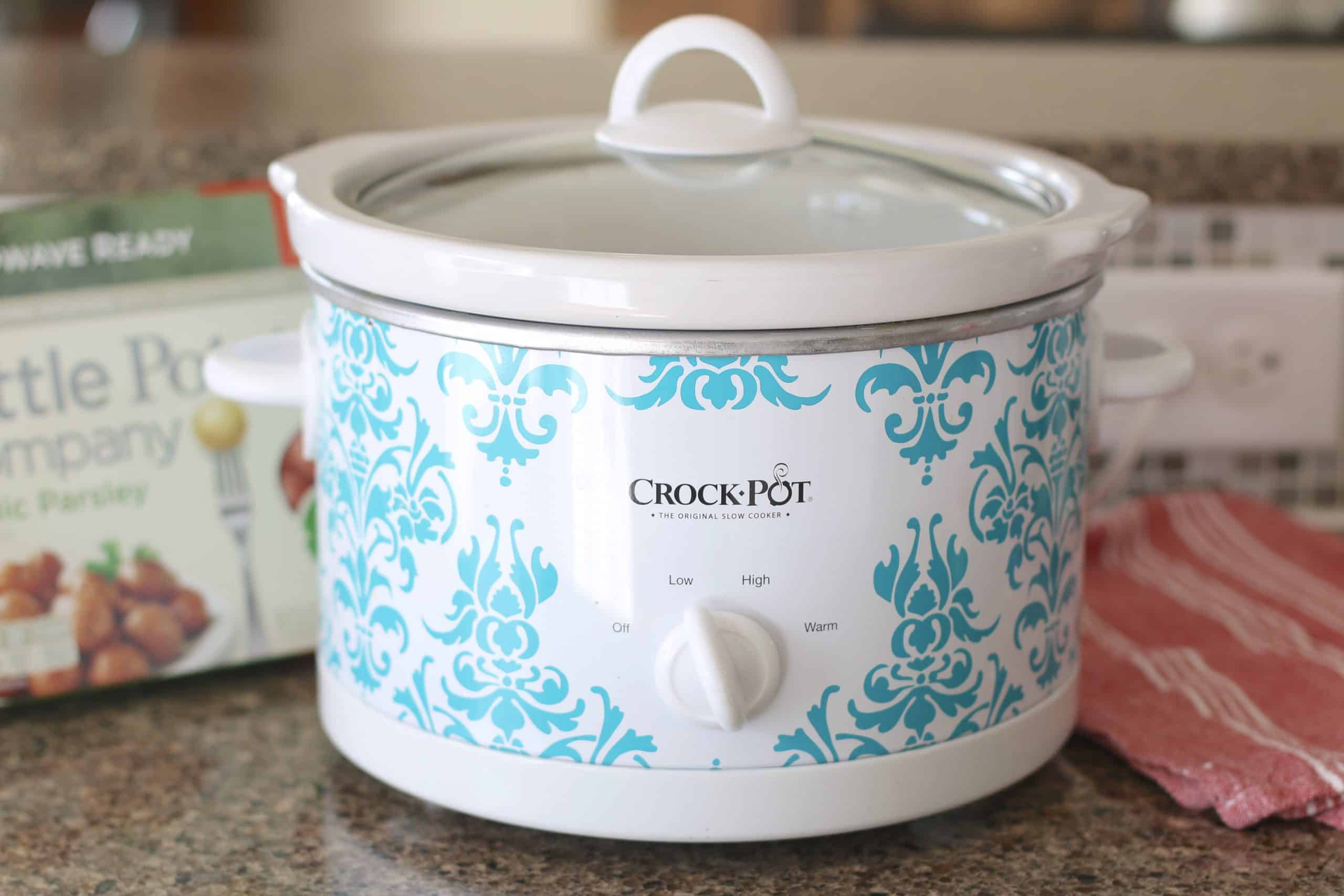white and blue slow cooker with the cover on.