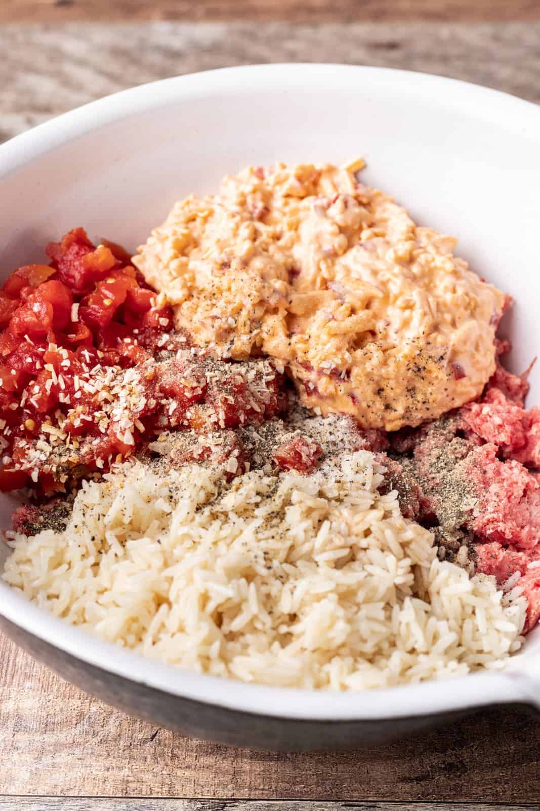 pimento cheese, rice, ground beef, Rotel and salt and pepper shown in a large bowl. 