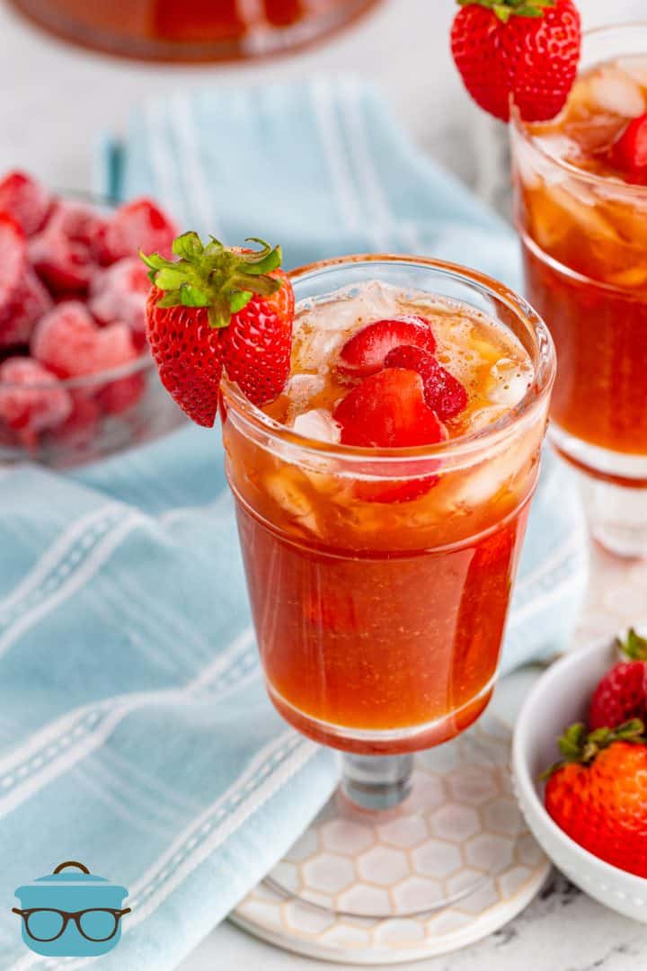 strawberry iced tea in a glass garnished with a fresh strawberry