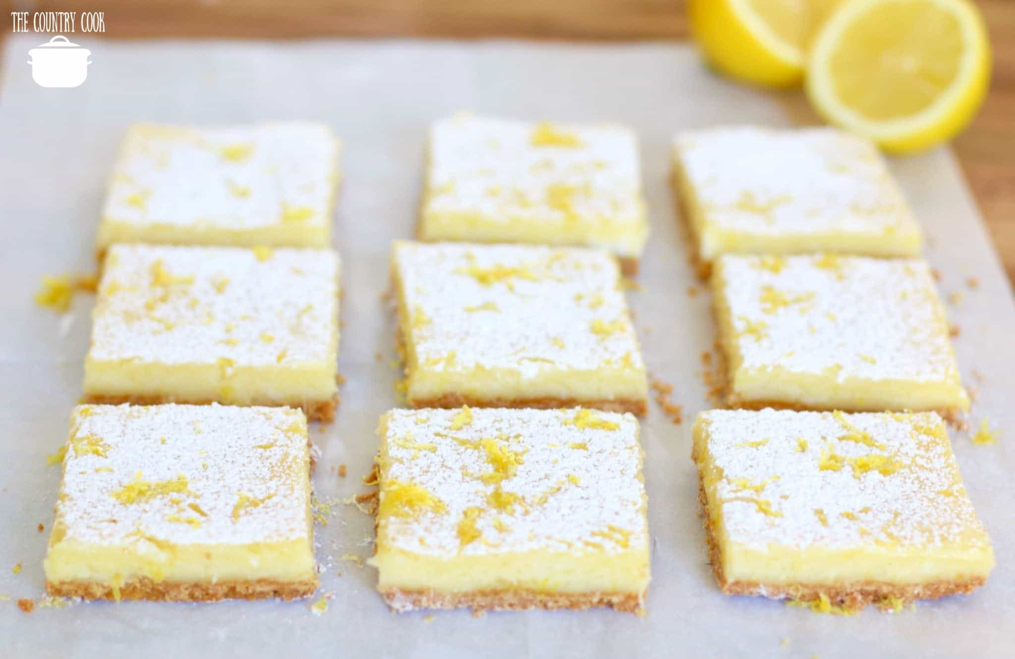Cream Cheese Lemon Bars, sliced with fresh lemons.