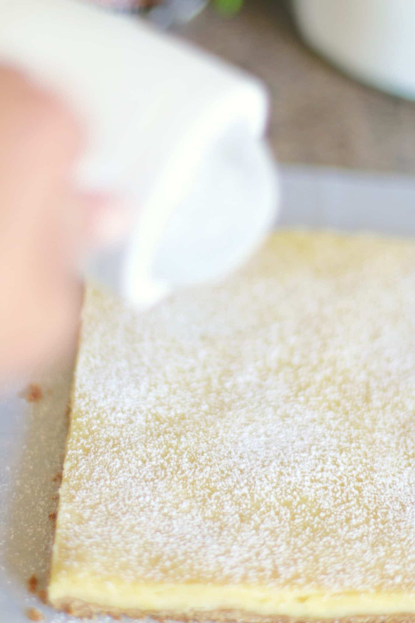 dusting powdered sugar on top of baked lemon bars.