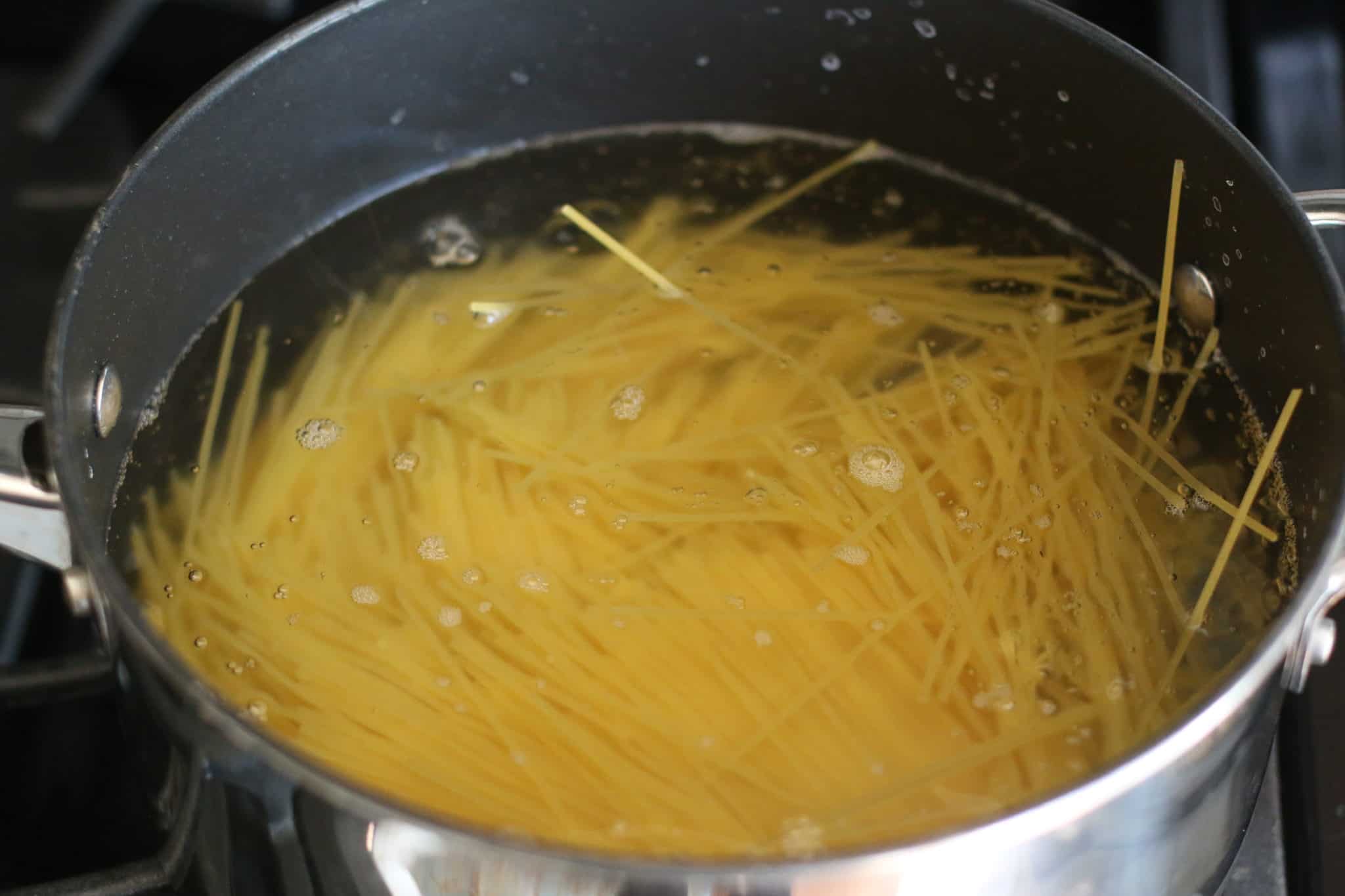 pot sized spaghetti noodles cooking in pot of boiling water