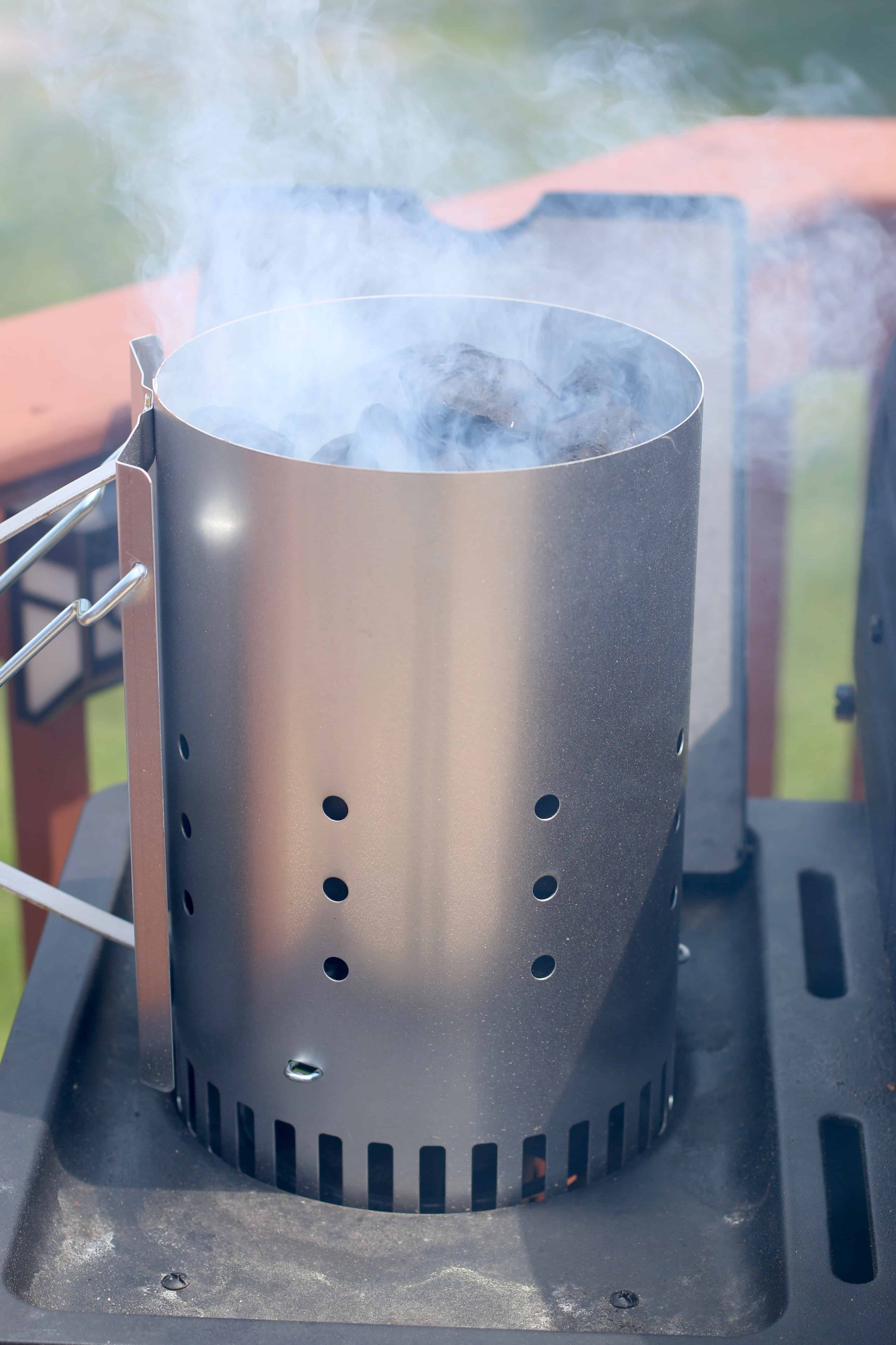 charcoal briquets creating smoke in a chimney starter.
