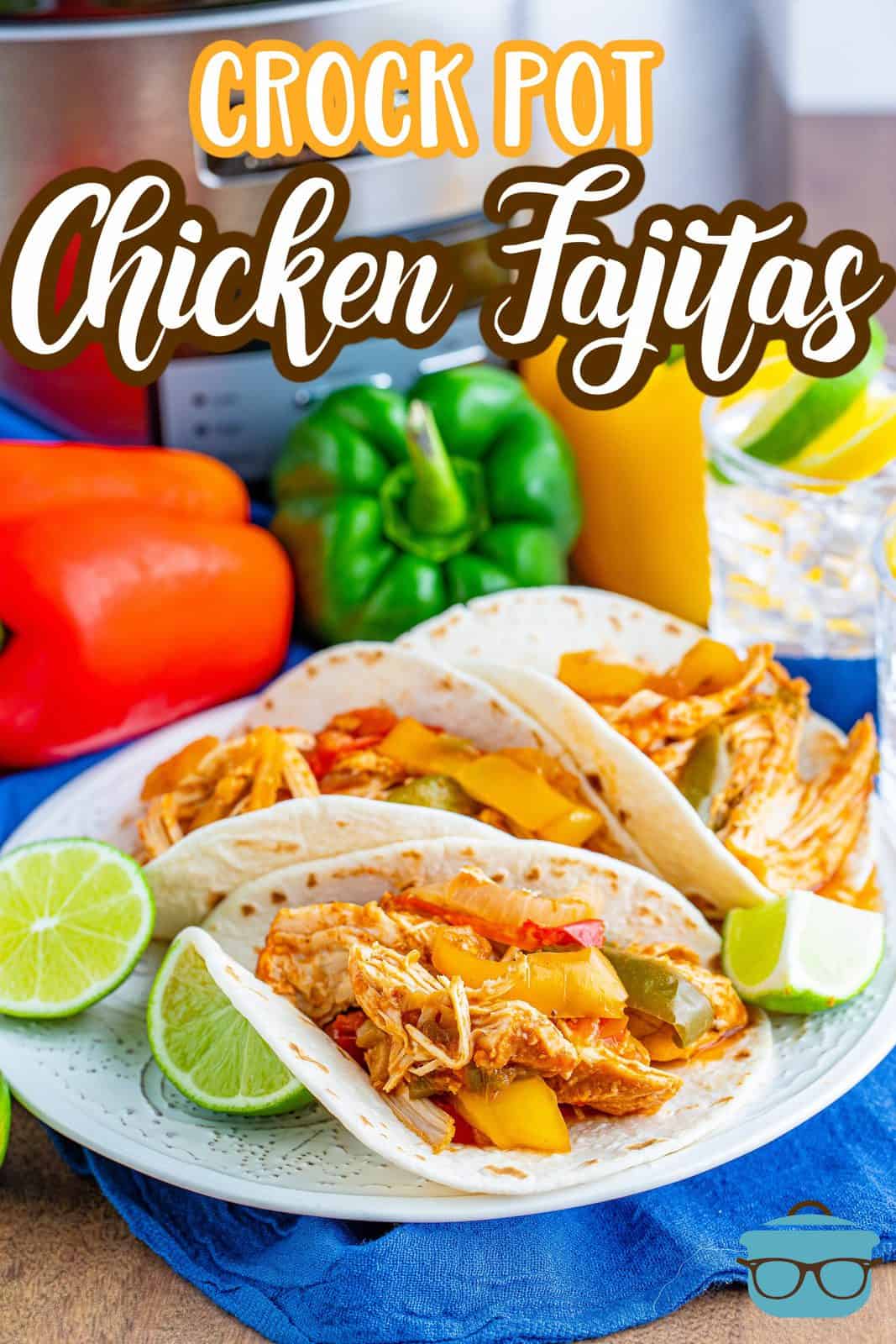 Crock Pot Chicken Fajitas recipe from The Country Cook, fajita filled flour tortillas shown on a white plate with slices of lime.