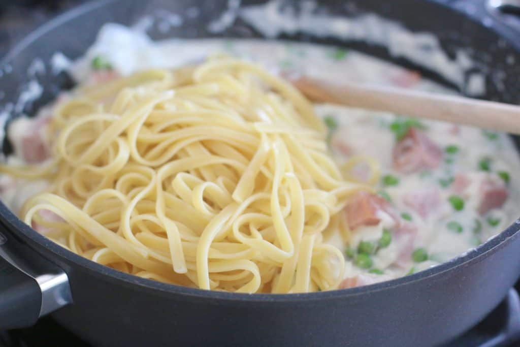 cooked fettuccine noodles added to ham and pea sauce