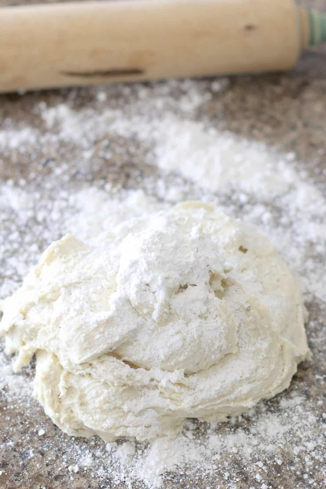 dough ball covered in a flour on a floured counter top