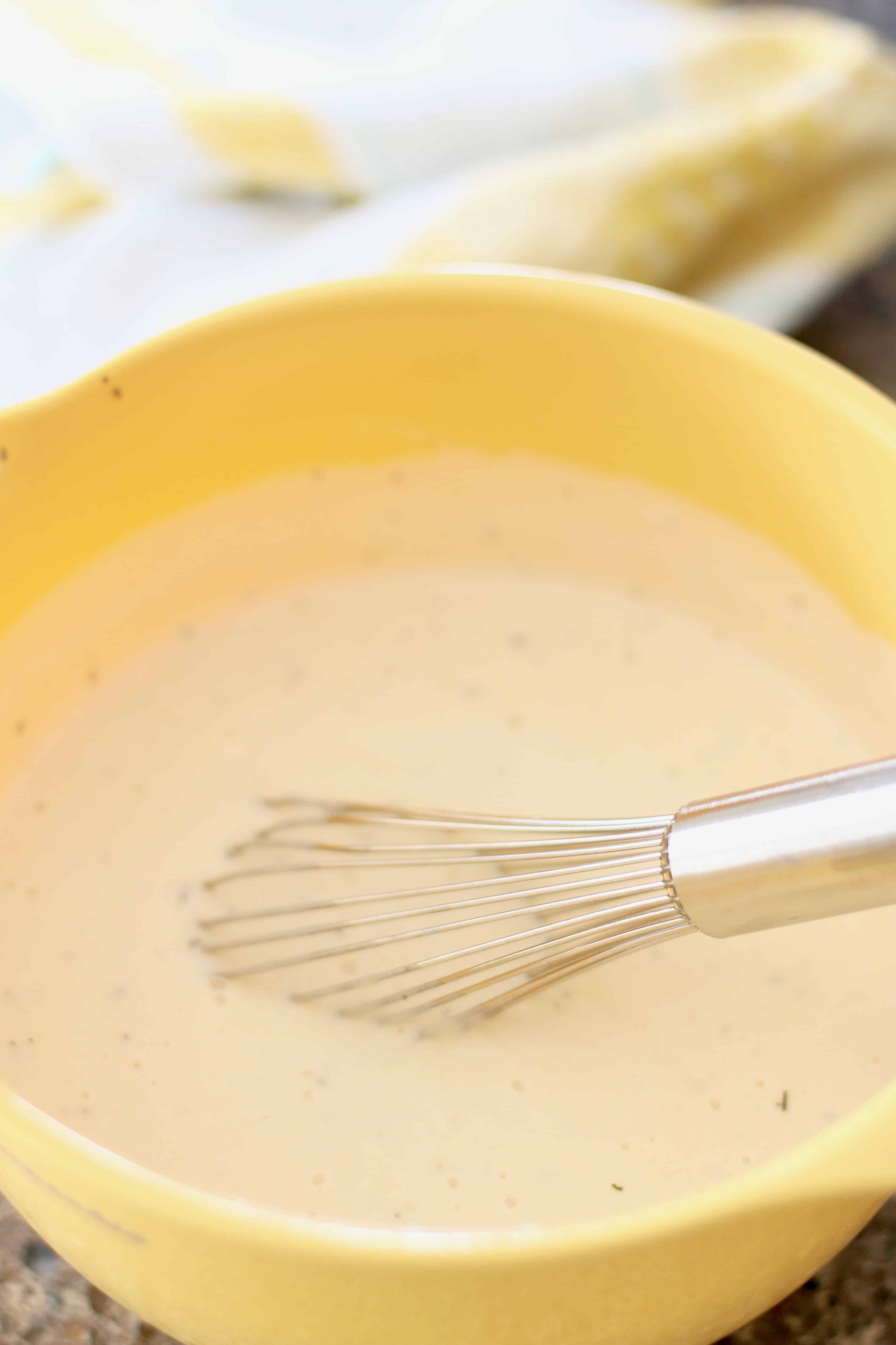 Alfredo sauce, water, garlic, Italian seasoning in a yellow bowl