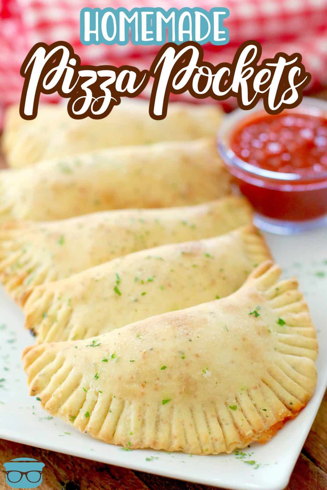 Homemade Pizza Pocket recipe. Hot pockets shown lined up on a white platter with a small bowl of pizza sauce.