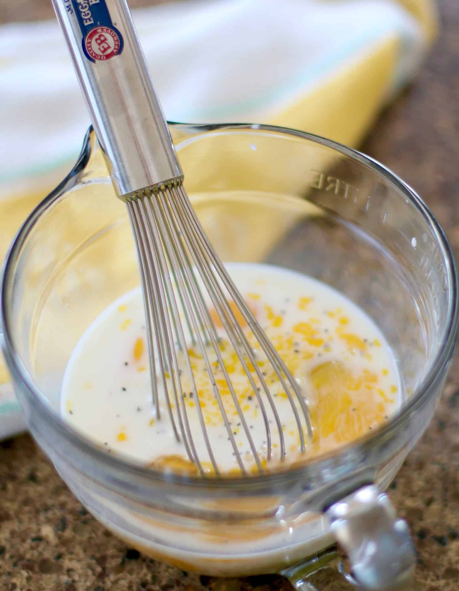 eggs, milk, salt and pepper whisked together in a Pampered Chef glass measuring cup bowl.