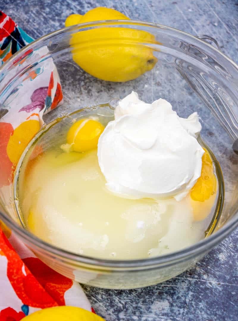 eggs, sugar, sour cream, eggs mixed together in a bowl.