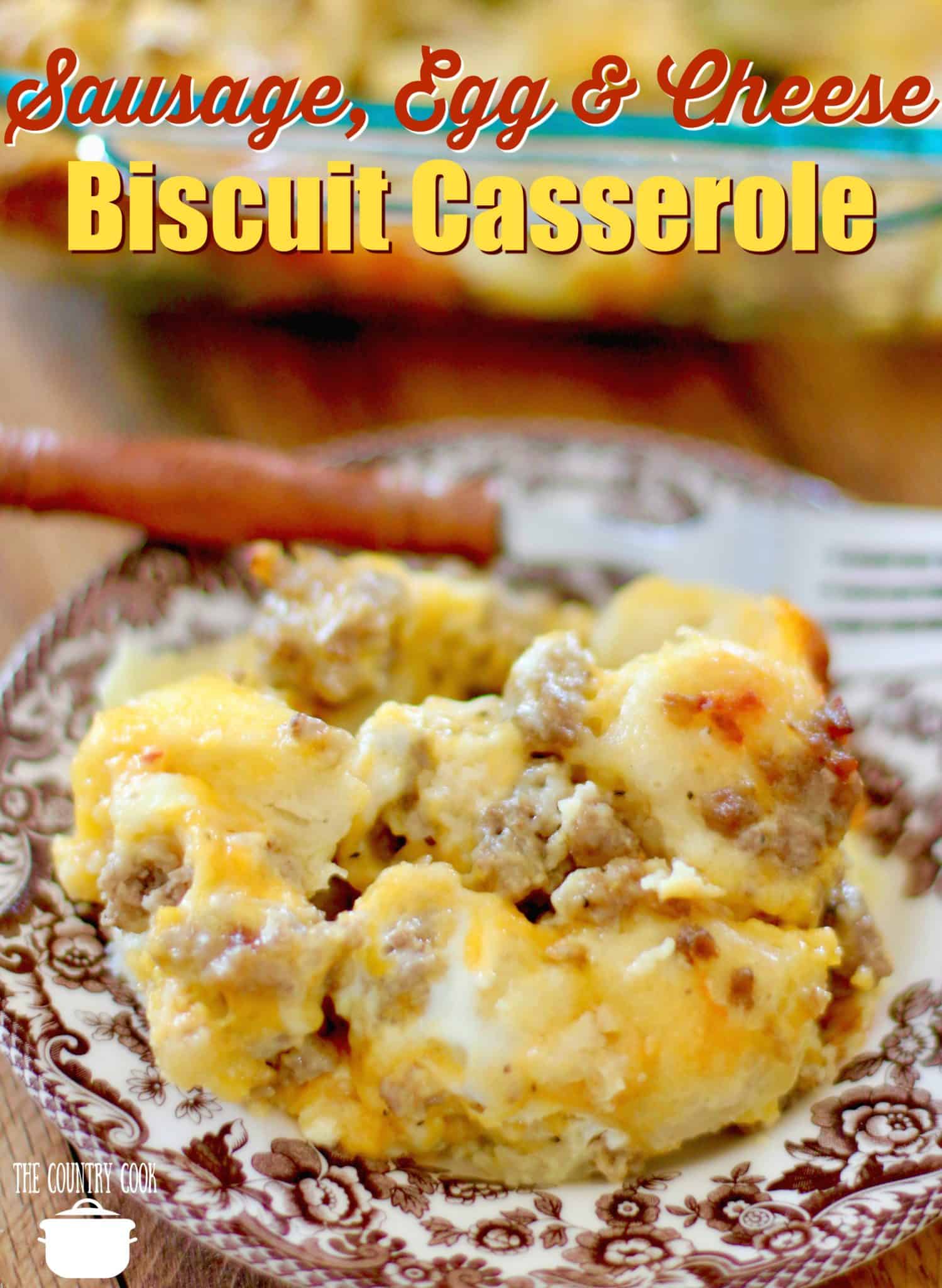 Sausage, Egg & Cheese Biscuit Breakfast Casserole recipe from The Country Cook. Slice shown on a brown and white plate with a fork in the background.