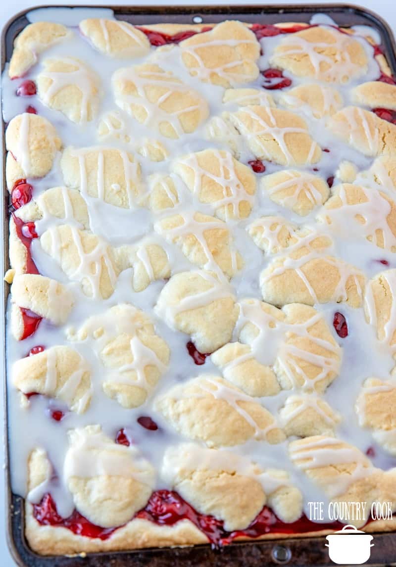 Cherry Pie Bars, fully baked with a powdered sugar icing drizzled on top.
