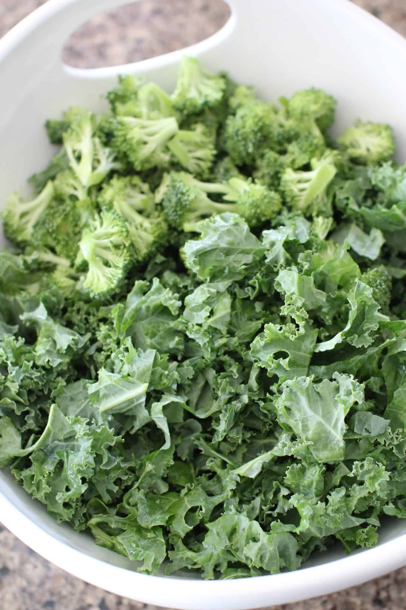 kale and broccoli shown in a large white bowl with handles.