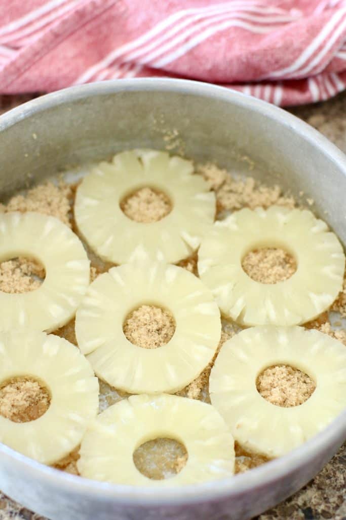 pineapple ring slices put in a single layer on  brown sugar in a baking pan