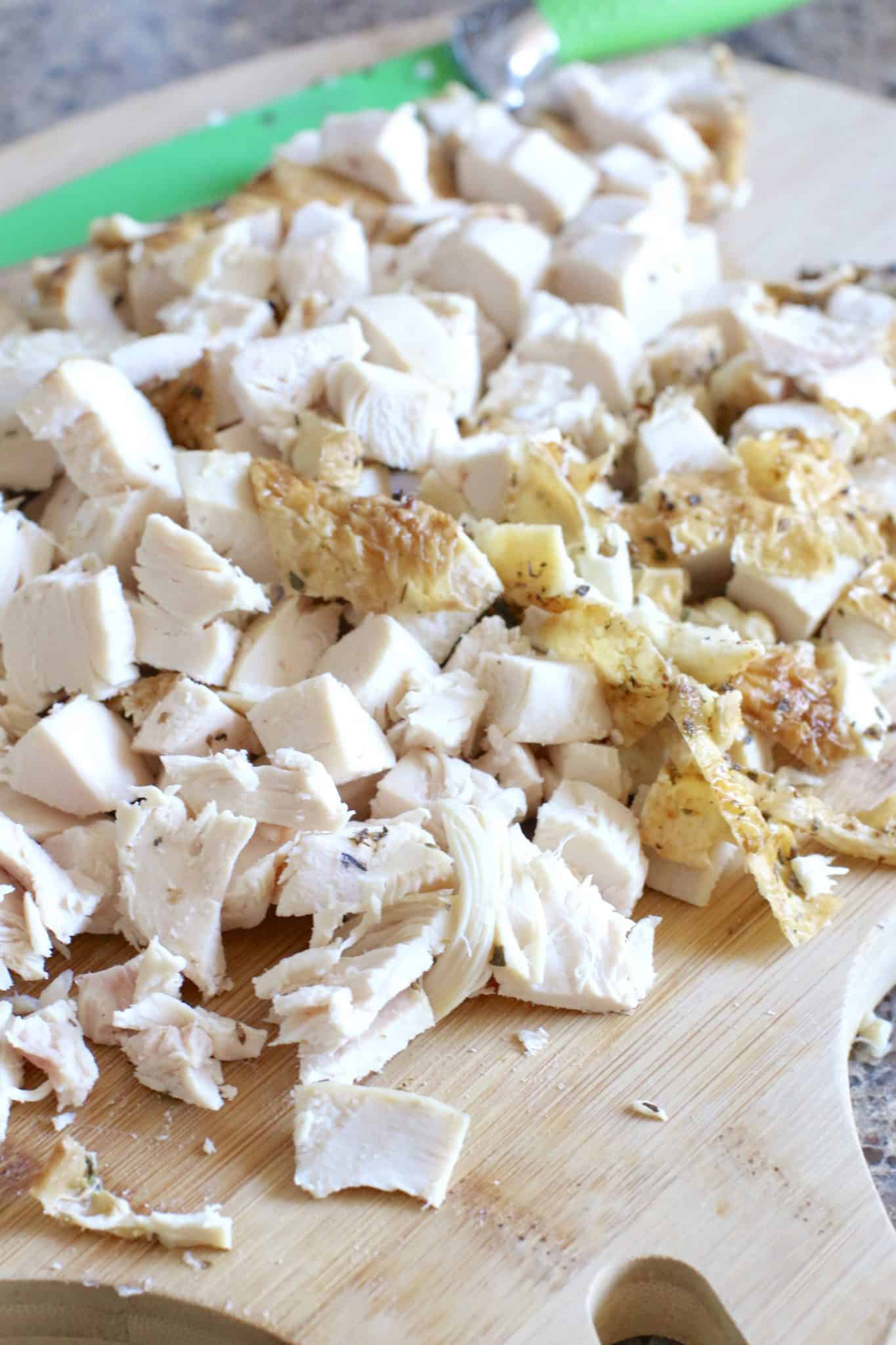 diced rotisserie chicken shown on a wooden cutting board. 