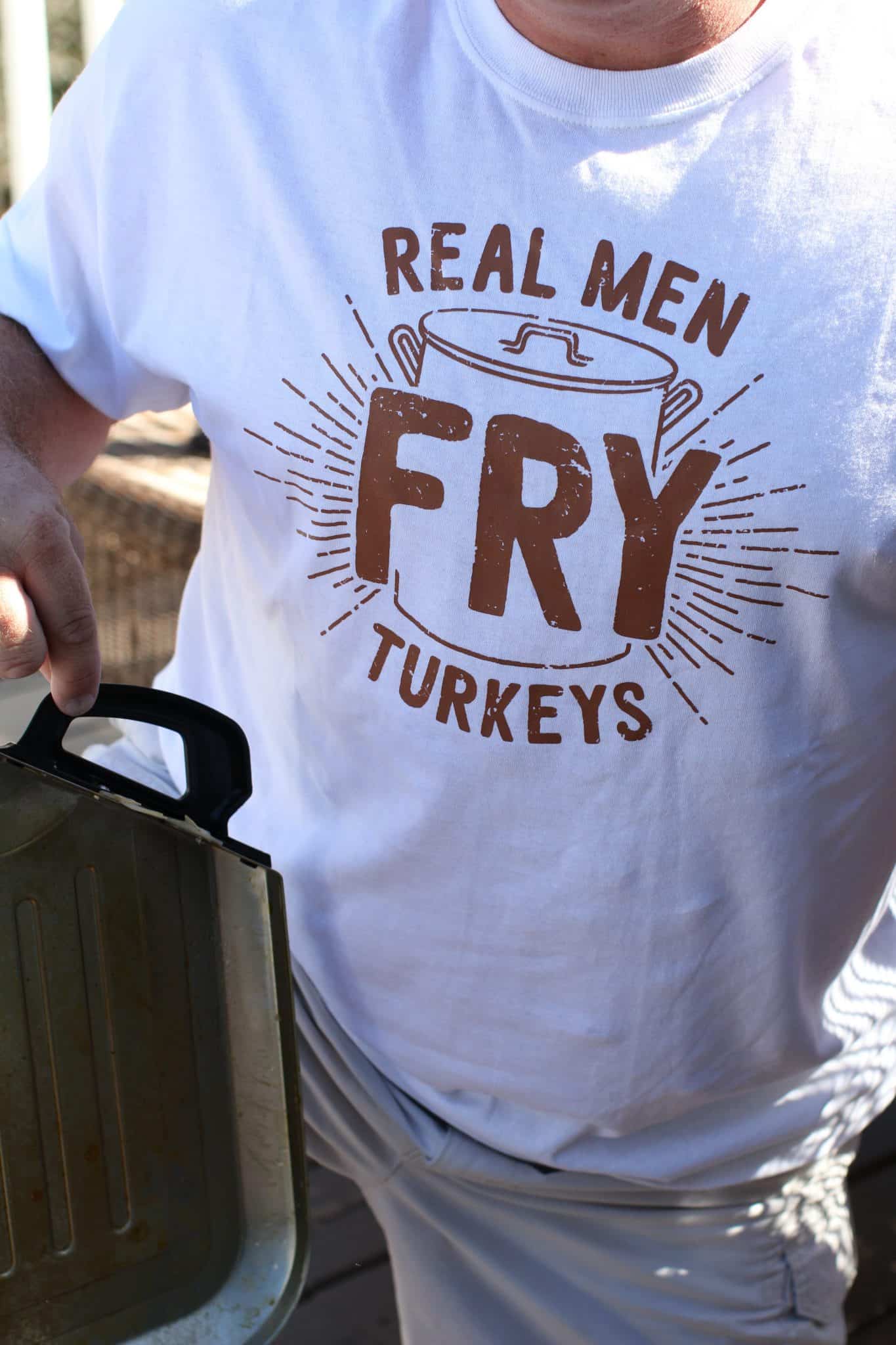 photo of a man wearing a t-shirt that says "Real Men Fry Turkeys".
