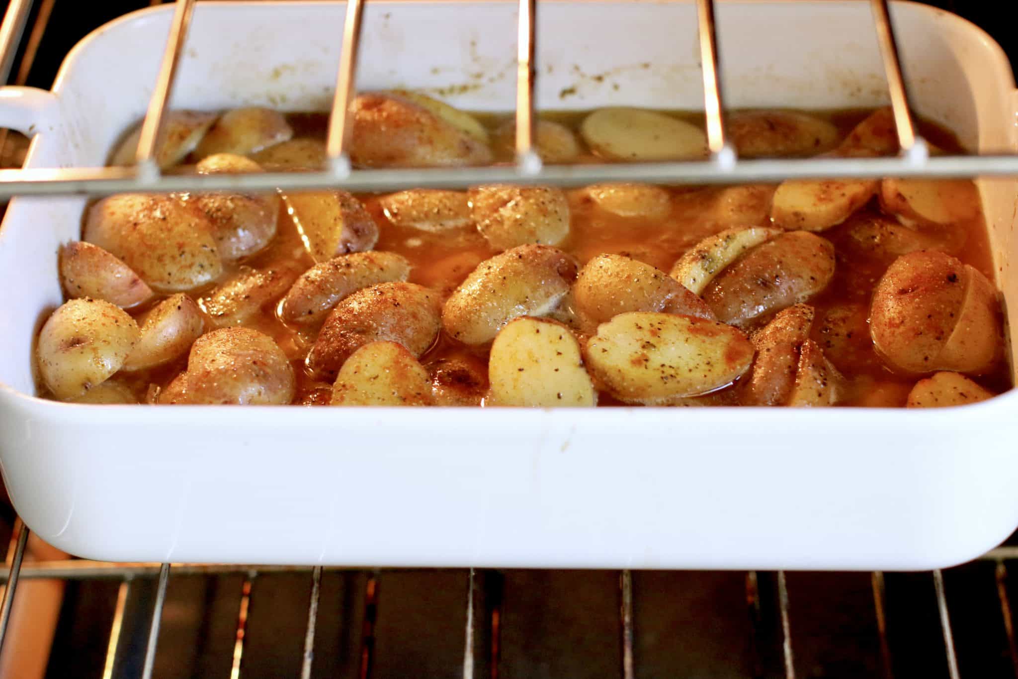cooked Greek potatoes shown in a baking dish inside the oven.